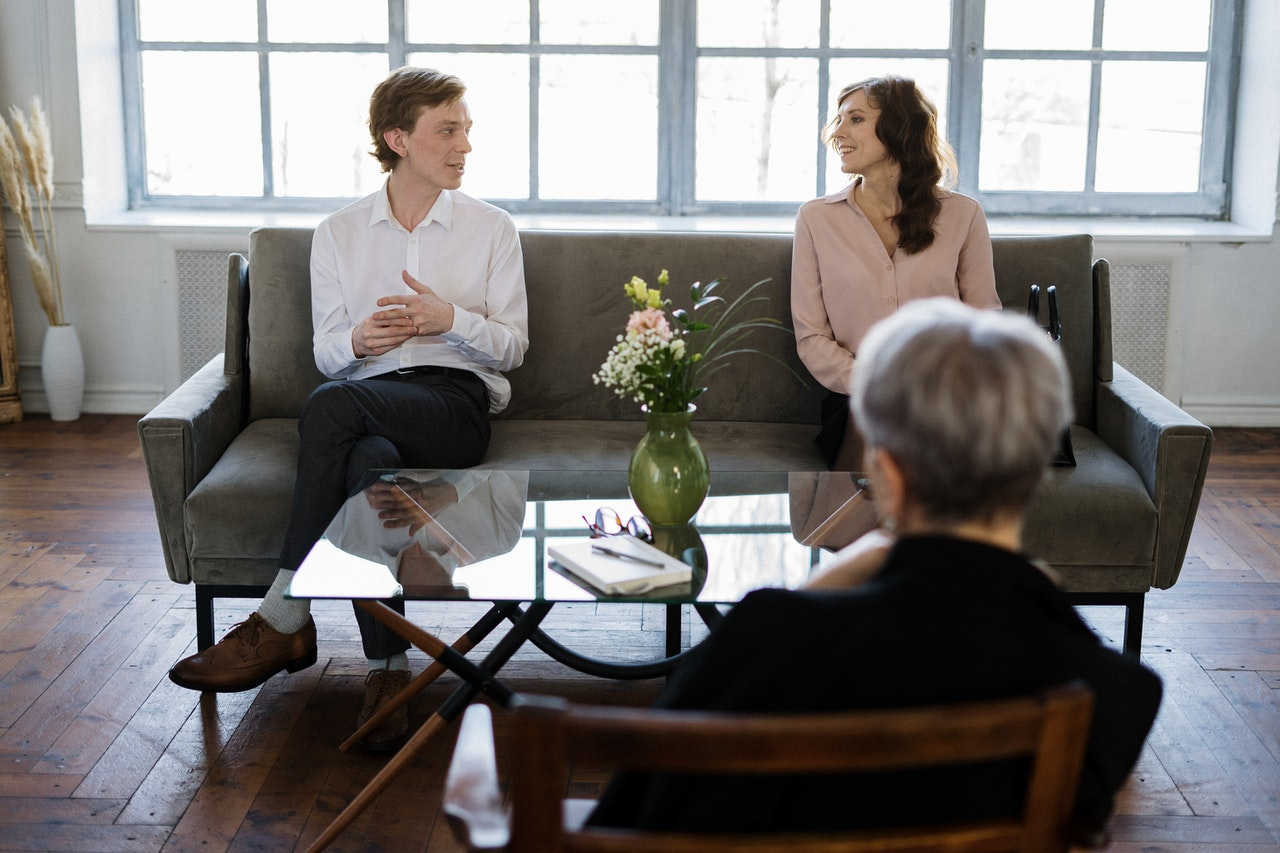 Couple during therapy session sitting on the couch in front of therapist