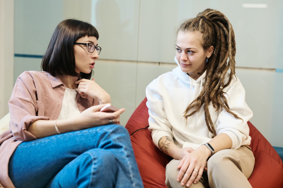 Doua femei stand pe fotoliu comunica asa cum comunica in cadrul consilierii psihologice