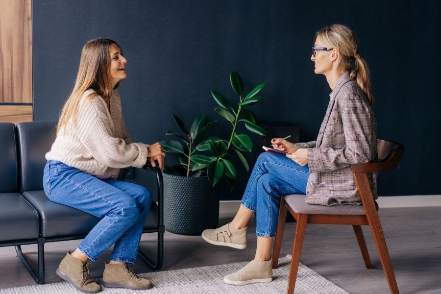 Psychotherapist discussing with her client smiling