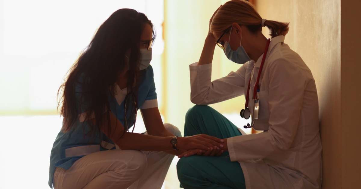 medic este asistat empatic de o asistenta pe holul unei clinici