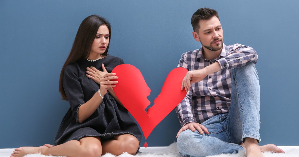 a couple hold the broken parts of a paper heart with their hands... sometimes it can be too late for couples therapy